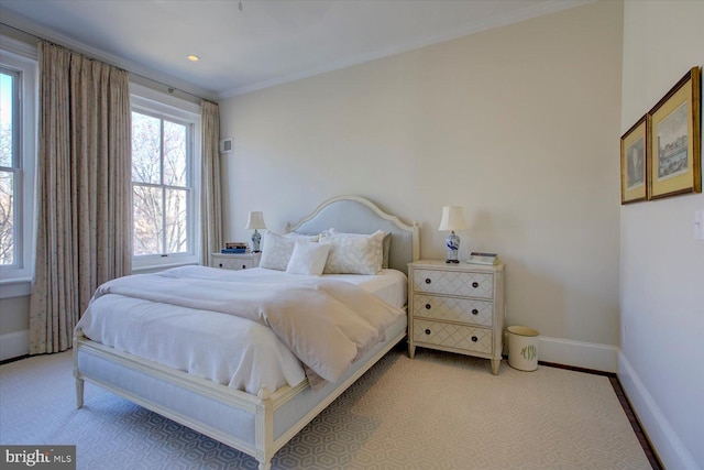 carpeted bedroom featuring crown molding and baseboards