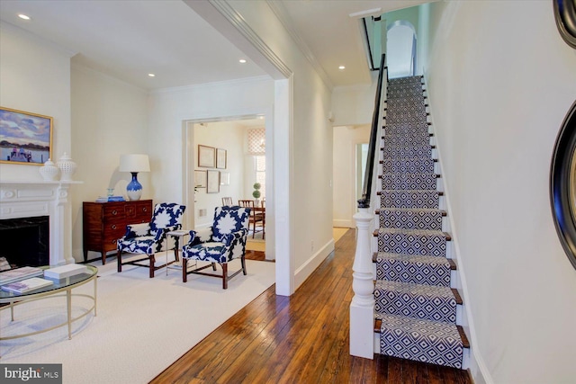 stairs featuring crown molding, a fireplace, baseboards, and wood-type flooring