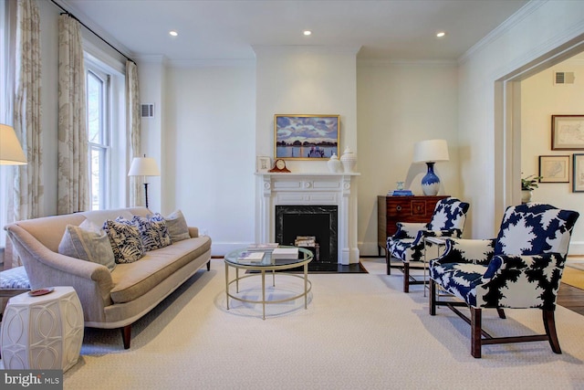 living area with visible vents, a premium fireplace, and ornamental molding