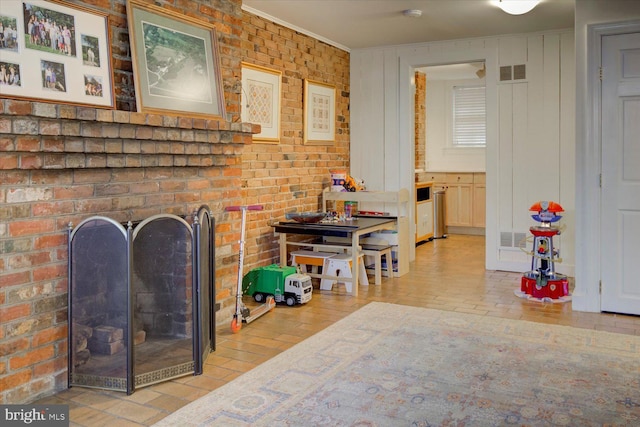 interior space featuring visible vents, a brick fireplace, and brick wall