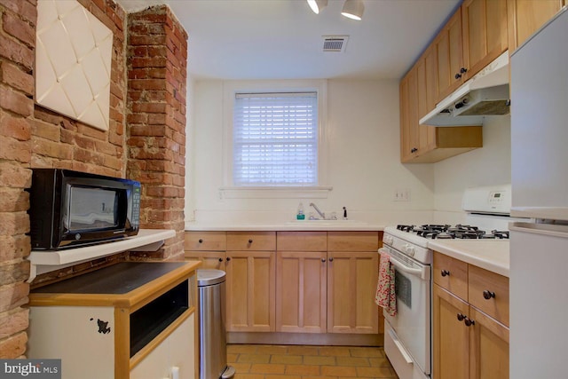 kitchen with visible vents, under cabinet range hood, a sink, white appliances, and light countertops