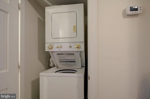 laundry room featuring stacked washer / drying machine and laundry area