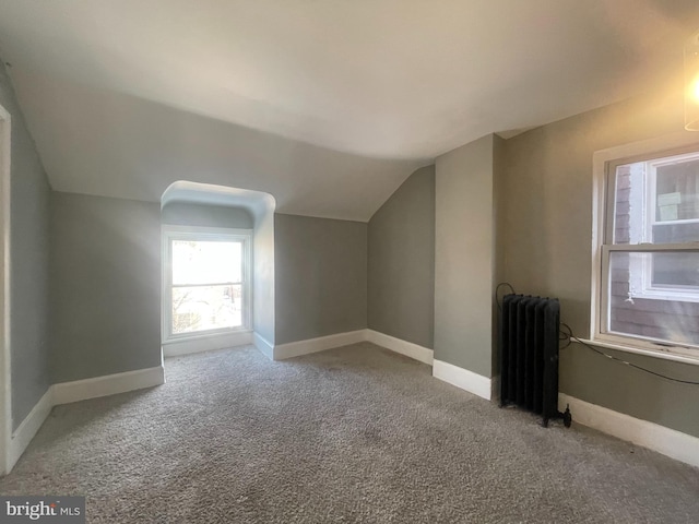 bonus room with carpet flooring, radiator, and vaulted ceiling