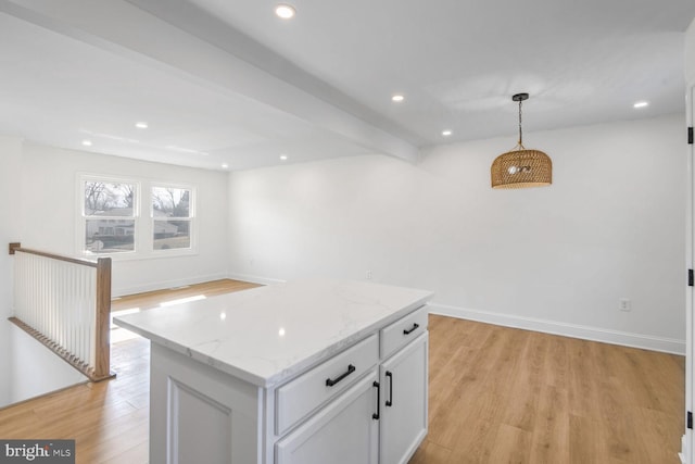 kitchen featuring a kitchen island, pendant lighting, white cabinets, light hardwood / wood-style floors, and beam ceiling