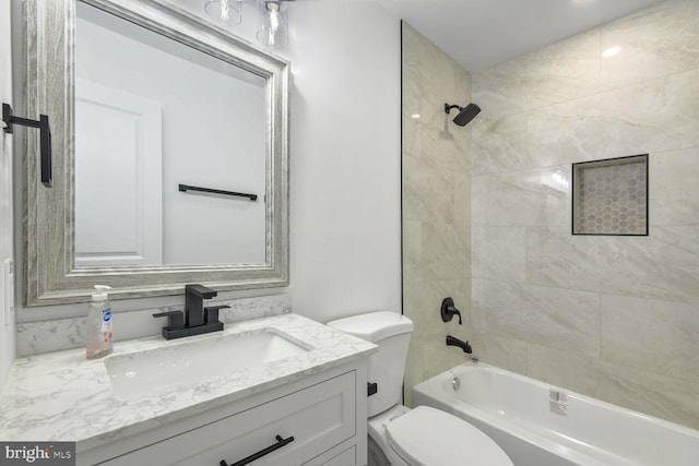 full bathroom with vanity, tiled shower / bath combo, and toilet