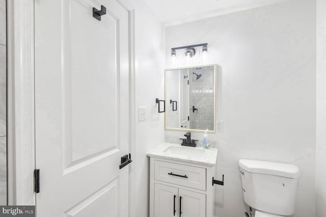 bathroom with vanity, a shower, and toilet