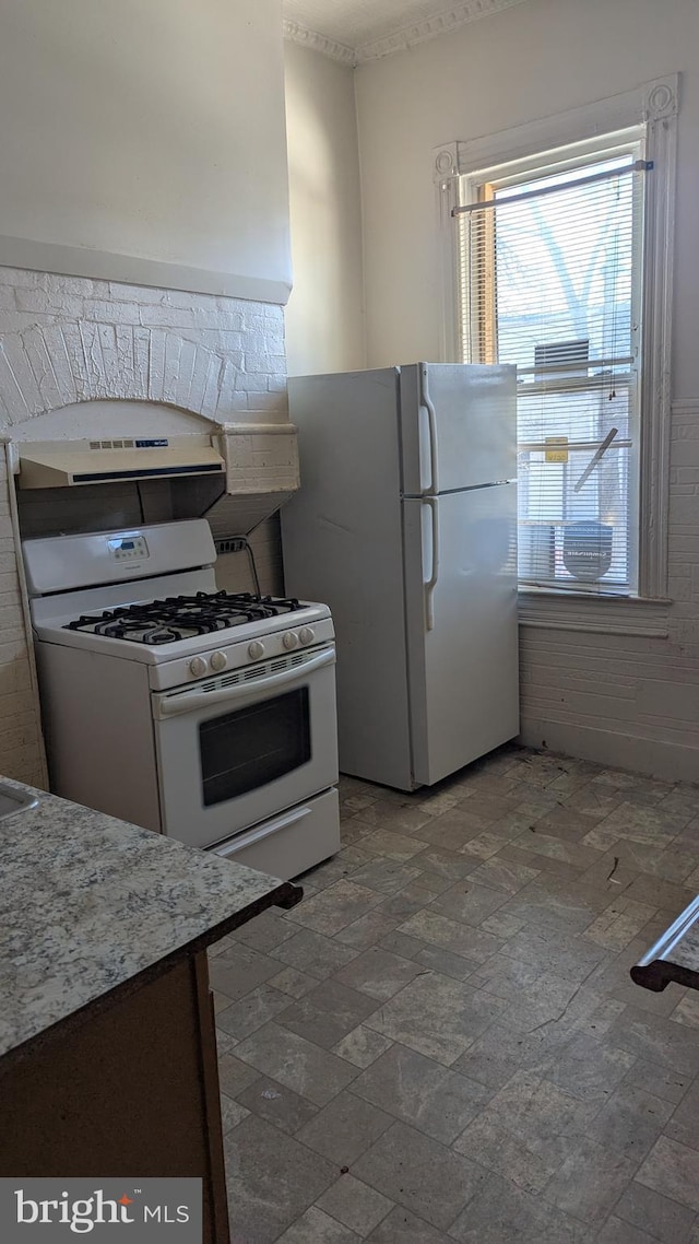 kitchen featuring white appliances and exhaust hood