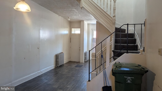 foyer with radiator heating unit and a textured ceiling