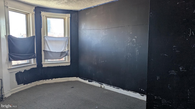 unfurnished room featuring a textured ceiling