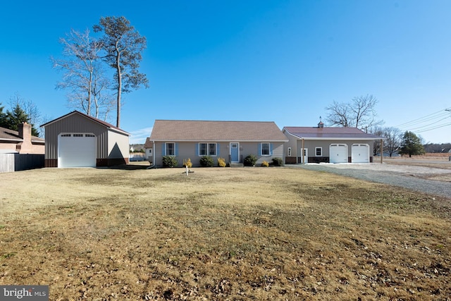 single story home with a detached garage and a front lawn