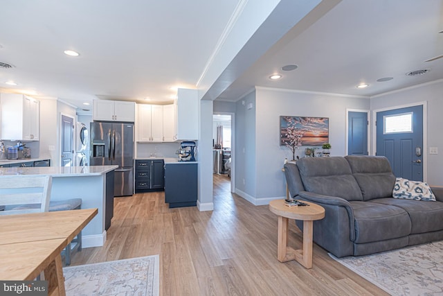 living room featuring crown molding and light hardwood / wood-style floors