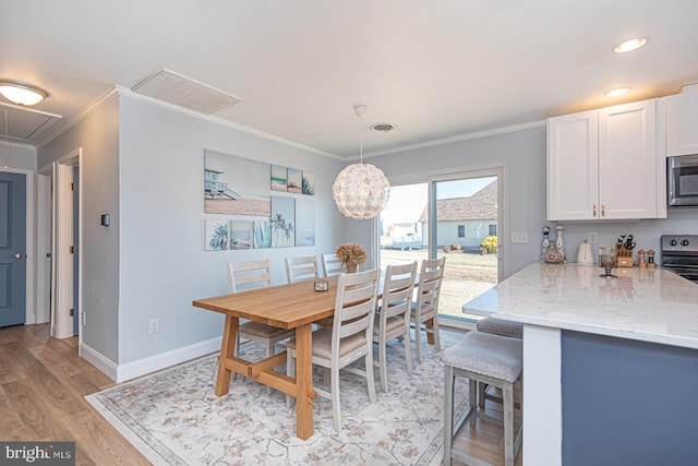 dining space featuring light hardwood / wood-style flooring and ornamental molding