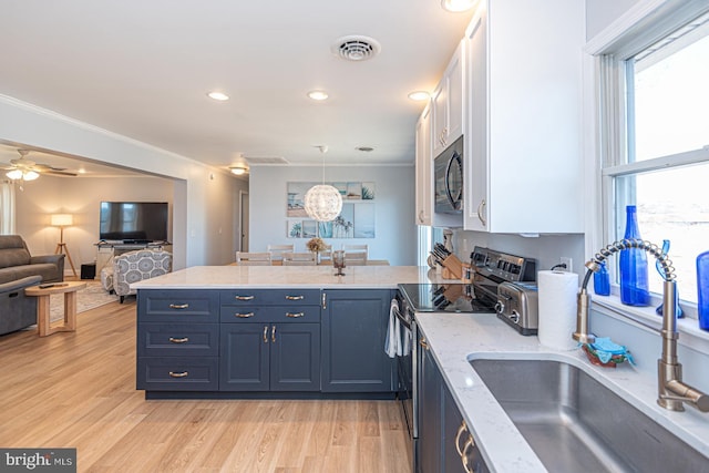 kitchen featuring sink, blue cabinetry, white cabinetry, hanging light fixtures, and black electric range