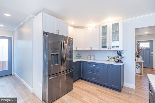 kitchen featuring white cabinets, blue cabinetry, and stainless steel fridge