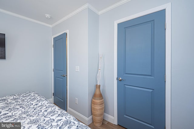 bedroom with ornamental molding and hardwood / wood-style floors