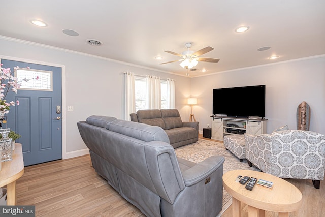 living room featuring ornamental molding, ceiling fan, and light wood-type flooring