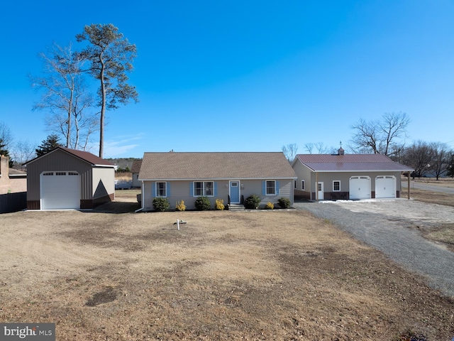 single story home featuring an outbuilding and a garage