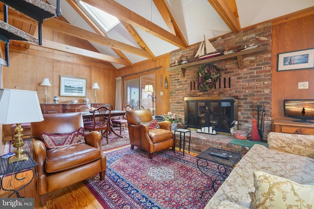 living room with a brick fireplace, a skylight, beamed ceiling, and wood walls