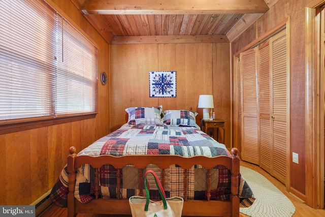 bedroom with beamed ceiling, wooden ceiling, wooden walls, and a baseboard heating unit