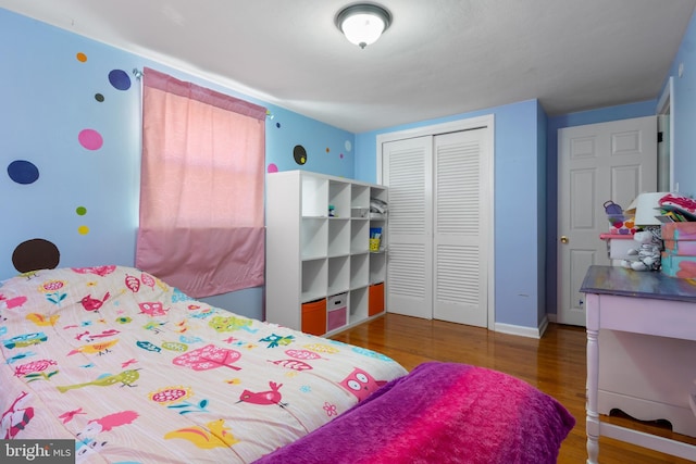 bedroom with dark wood-type flooring and a closet