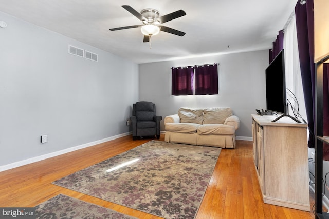 living room with hardwood / wood-style flooring and ceiling fan