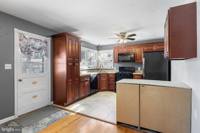 kitchen with ceiling fan, light hardwood / wood-style floors, sink, and black appliances