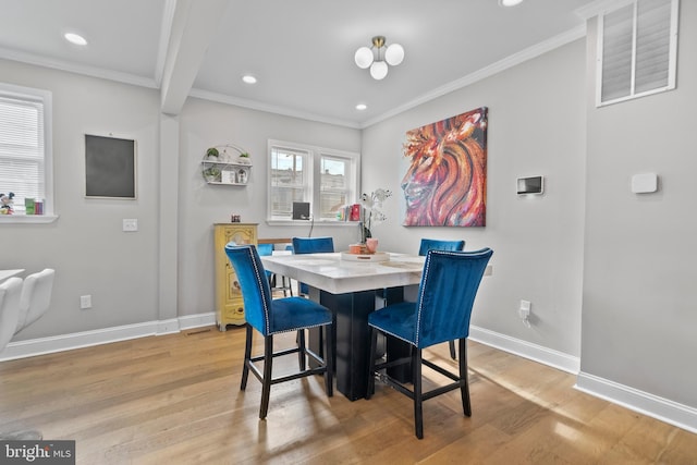 dining room with light hardwood / wood-style flooring, ornamental molding, and beamed ceiling