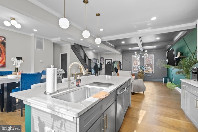 kitchen featuring beamed ceiling, an island with sink, dishwasher, sink, and hanging light fixtures