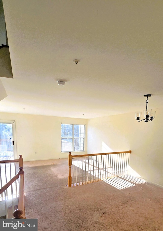 hall featuring an inviting chandelier and carpet floors