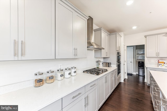 kitchen featuring dark hardwood / wood-style floors, wall chimney exhaust hood, and appliances with stainless steel finishes