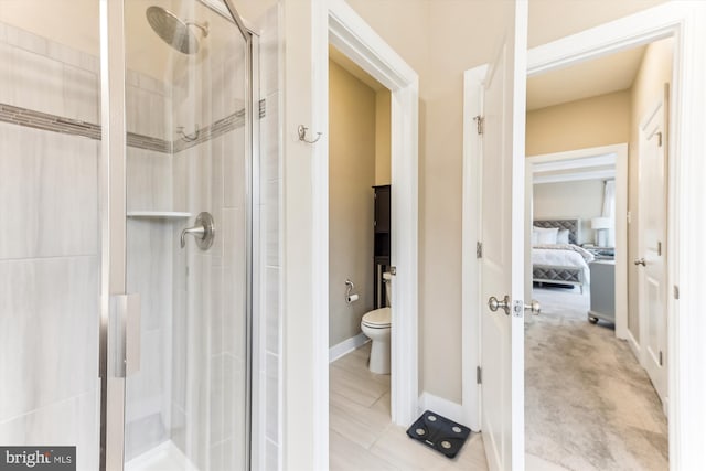 bathroom featuring toilet and a shower with door