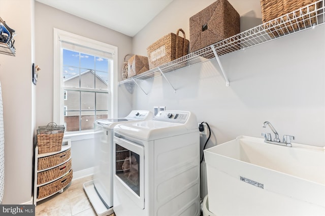 clothes washing area with sink, tile patterned floors, and independent washer and dryer