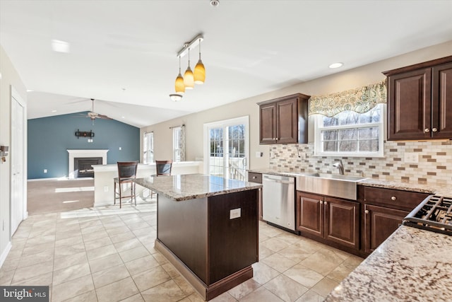 kitchen featuring pendant lighting, a wealth of natural light, dishwasher, and vaulted ceiling