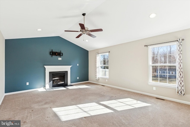 unfurnished living room featuring ceiling fan, light colored carpet, and vaulted ceiling