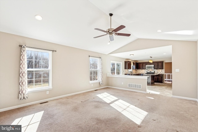 unfurnished living room featuring ceiling fan, vaulted ceiling, and light carpet