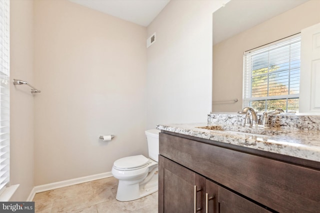 bathroom with vanity, tile patterned flooring, and toilet