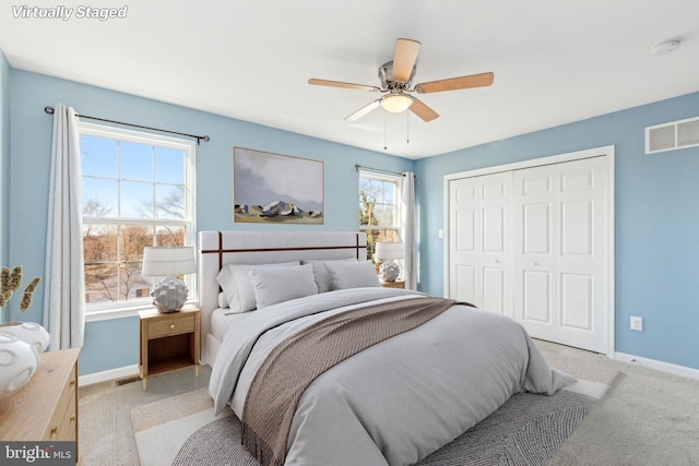 carpeted bedroom with ceiling fan and a closet