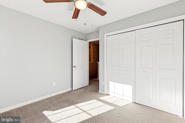 unfurnished bedroom featuring ceiling fan, a closet, and light carpet