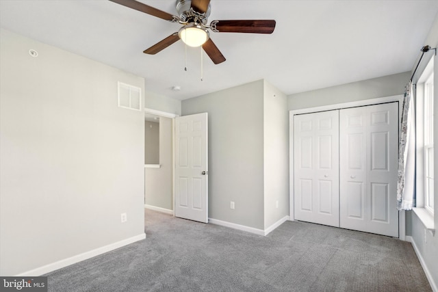 unfurnished bedroom with light colored carpet, a closet, and ceiling fan