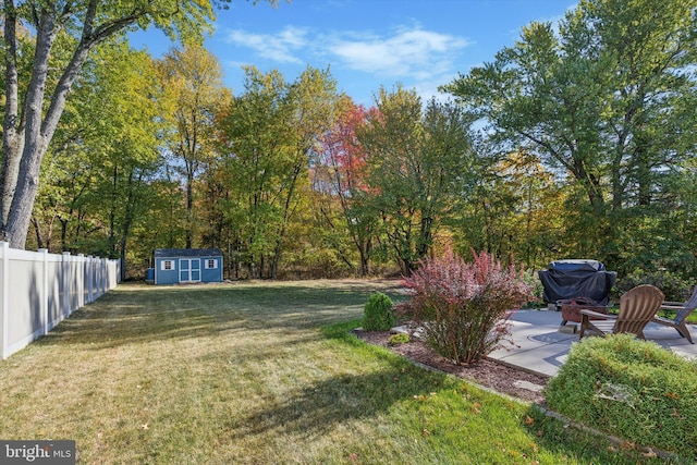 view of yard with a storage shed, a patio area, and a fire pit