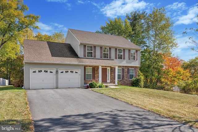 colonial home with a garage and a front lawn