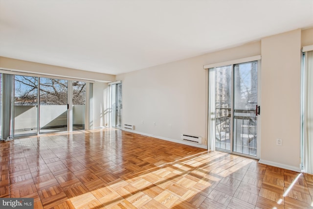 unfurnished room with a baseboard radiator and light parquet flooring