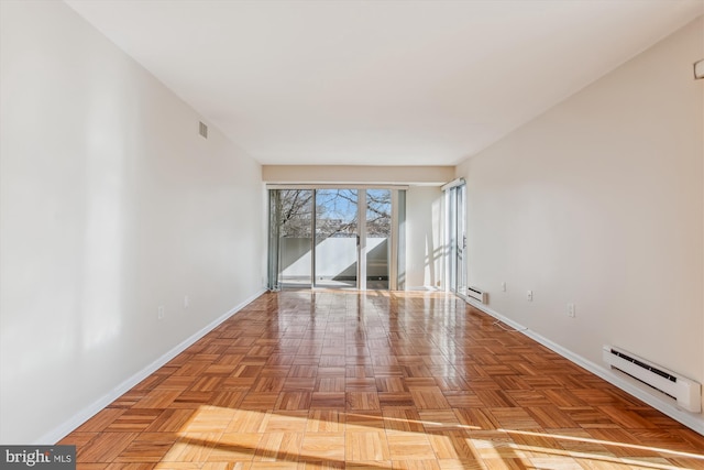 spare room featuring light parquet floors and baseboard heating