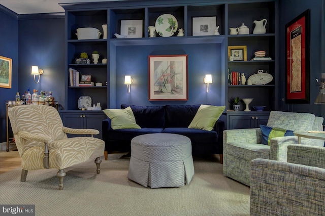 living area with built in shelves and crown molding