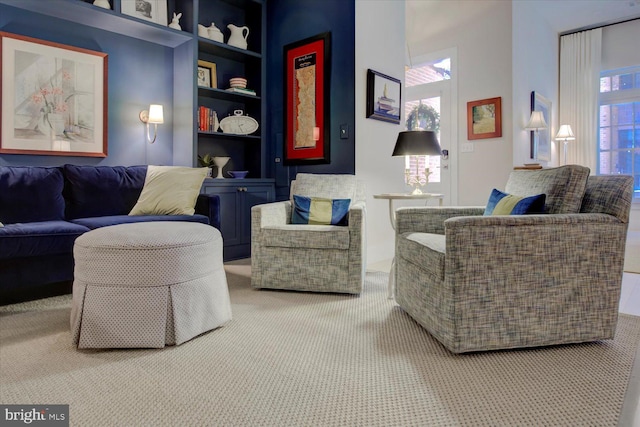 carpeted living room featuring built in shelves and a towering ceiling