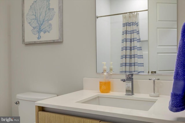 bathroom with toilet, a shower with shower curtain, and vanity