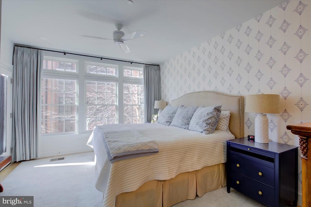 bedroom featuring visible vents, ceiling fan, and wallpapered walls