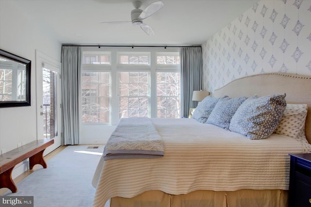 carpeted bedroom featuring wallpapered walls, access to outside, and ceiling fan