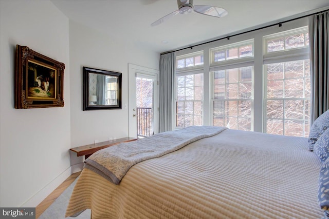 bedroom with access to outside, ceiling fan, baseboards, and wood finished floors