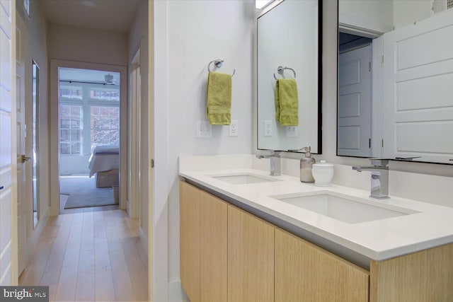 bathroom with double vanity, wood finished floors, and a sink